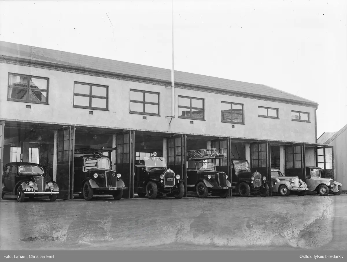Sarpsborg brannstasjon med brannbiler og utrykningsbiler og sykebil/ambulanse.  Den største bilen har Magirus-stige. 
Kjennetegn Brand 1, Brand 3, Brand 2, Brand 4, bilen til venstre har kjennetegn B-50 en  Ford V8 1937 modell,  sykebil med kjennetegn B-58 Packard 1937-modell, og bil med B-53.