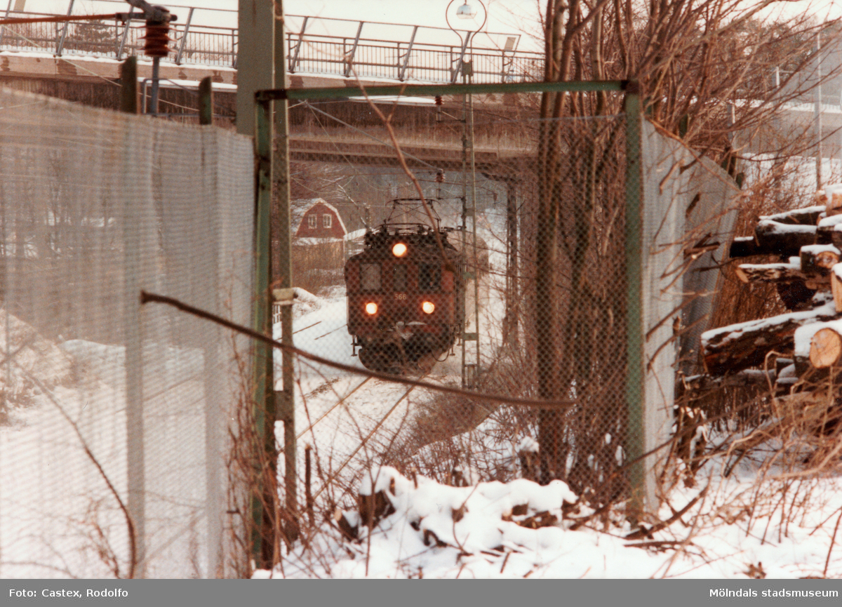 Ett tåg passerar under en bro i Grevedämmet, Mölndal, i januari 1984.