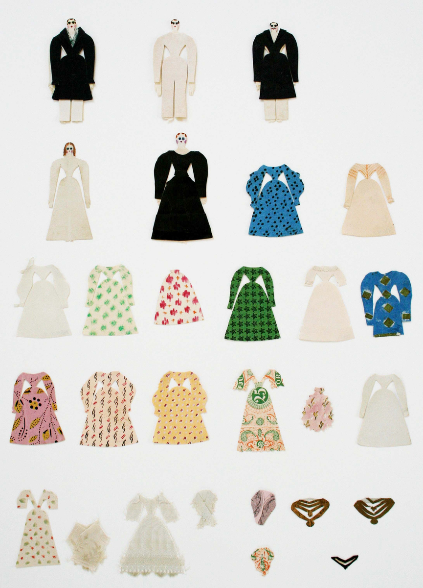 Dockor med små huvuden. Kläder klippta av olika slags enfärgade och mönstrade papper (tryckta, handmålade). Kläderna har smala midjor, vida kjolar och ärmar.

Herrkläder: kostymer, rockar.

Damkläder: klänningar, blusar, kjolar, sjalar och halsband. I cellofanmappar.

1. 3 män, 2 kvinnor, påklädda +1 rock, 14 klänningar, 1 kjol, 1 förkläde, 4 sjalar och 2 halsband.

2. 34 klänningar.

3. 10 klänningar, 1 blus, 3 sjalar.

4. 42 klänningar, 1 blus, 1 byxa, 10 sjalar.

5. Påklädd man + 3 rockar, 1 blus, 1 jacka, 5 klänningar, 2 kjolar, 5 sjalar. Låg i litet kuvert märkt "Maris dockor".

6. 11 kjolar, 2 blusar, 13 sjalar.

7. 20 fyrkantiga sjalar, de flesta med klippt frans. Låg i vikt papper märkt "Anguelie".

8. 13 fyrkantiga sjalar varav 9 med klippt frans, 3 små sjalar, 1 klänning. Låg i vikt papper märkt "Marias".

9. 6 små sjalar, 1 halsduk. Låg i liten svart och guldfärgad pappask tillsammans med litet brev från "Albertina".