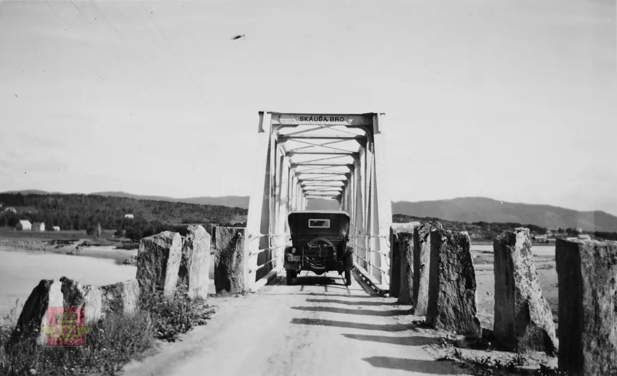 Skauga bru i Uddu, Rissa.  Parallellfagverksbru i stål med mellomliggende kjørebane. 1909 står på enden av brua.
Bil reg.nr. U-280.