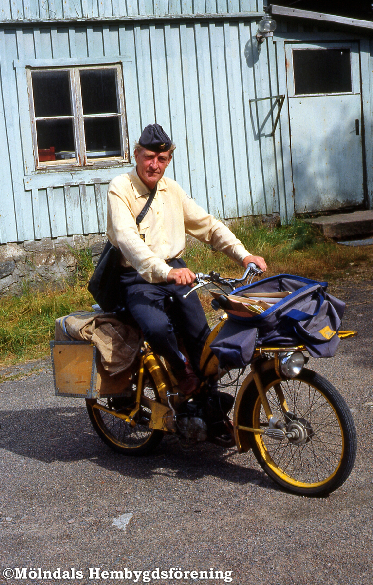 Lantbrevbärare Åke Mattsson, sittandes på moped, lämnar post på Östergården 6 i Balltorp, Mölndal, i juli 1989.