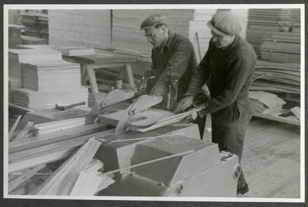 Foto av tremateriale og arbeidere med maskineri ved  Aall-Ulefoss Brugs Dørfabrikk
