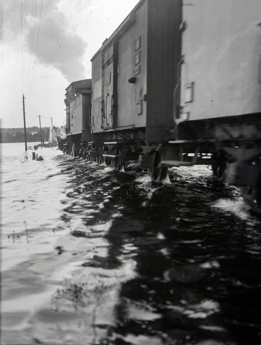 Hamar, Åkersvika, Mjøsflommen 1927, lokomotiv med jernbanevogner mot jernbanebrua, 10. juli vannstand 8,29 meter,
