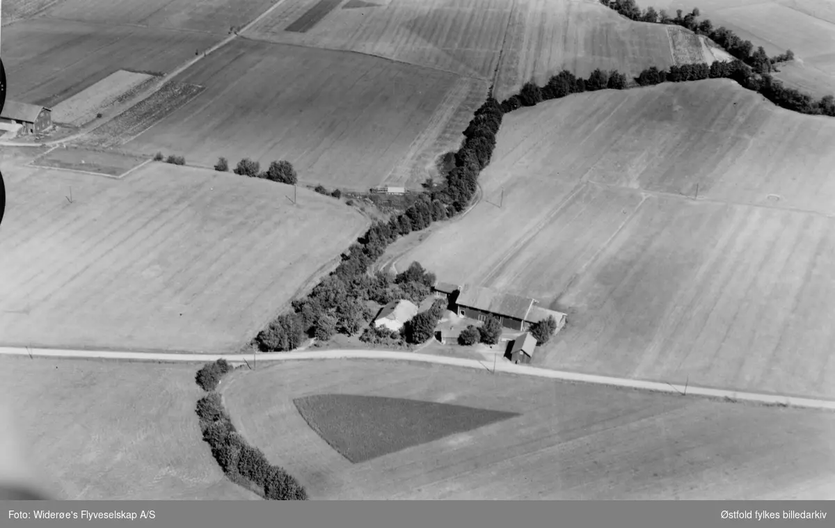 Skråfoto av gården Haugen 121/2 og helt til venstre litt av gården Haugen 121/3 og 4 til venstre (der hvor Tuneskipet ble funnet - rektangel). 24 juli  1952.