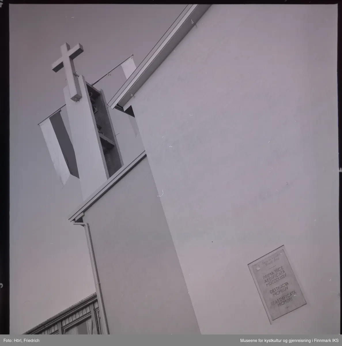 Ved klokketårnet til den katolske kirka St. Mikael i Hammerfest er det montert to stenger med vimpler. Det antas at dette ble gjort i anledning vigslingen den 3. august 1958. Ved kirkeveggen vises det en bronseplate med følgende inskripsjon.
"PRIMA VICE
AEDIFICATA (første gang bygget)
MDCCCLXXXV (1885)
DESTRUCTA (ødelagt)
MCMXLIV (1944)
REAEDIFICATA (gjenoppbygget)
MCMLVII (1957)"