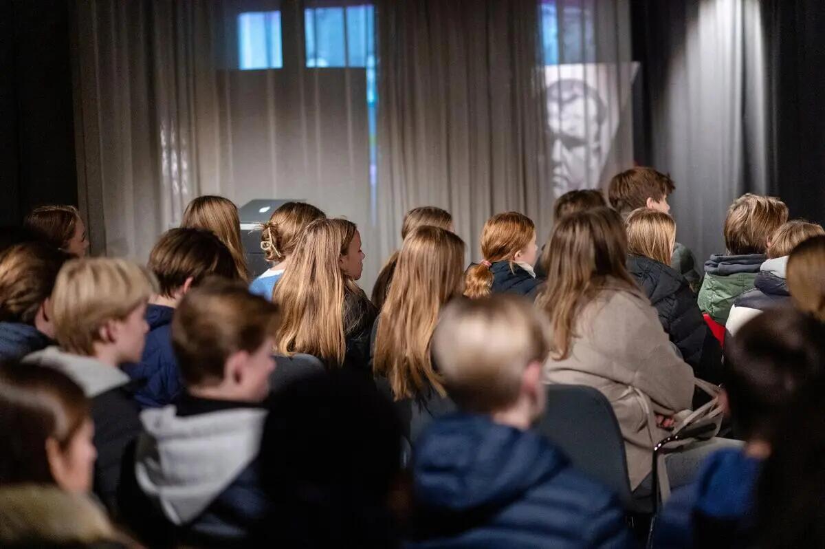 Fotografi tatt av elever som sitter og hører på et foredrag. De har ryggen til kamera og ansiktet vendt framover.