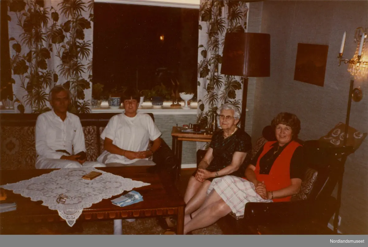 Interiør i en stue. Fire mennesker sitter i to sofaer. Klara Simonsen nr. tre fra venstre. Ellinor til høyre.