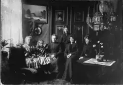 Gruppeportrett av seks kvinner og jenter, fotografert i en s