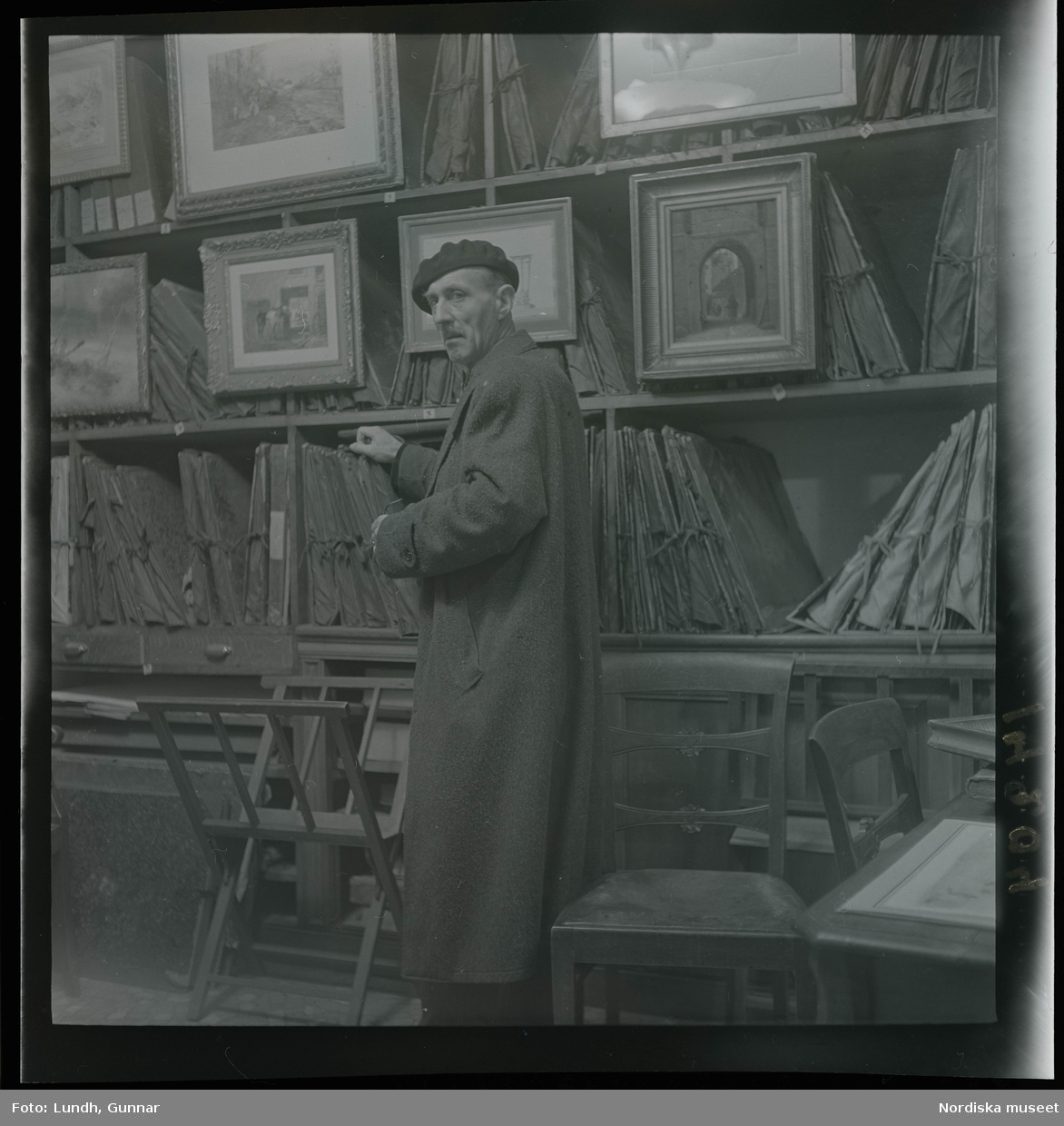 1950. Paris. En man stå inne i en butik med konst.