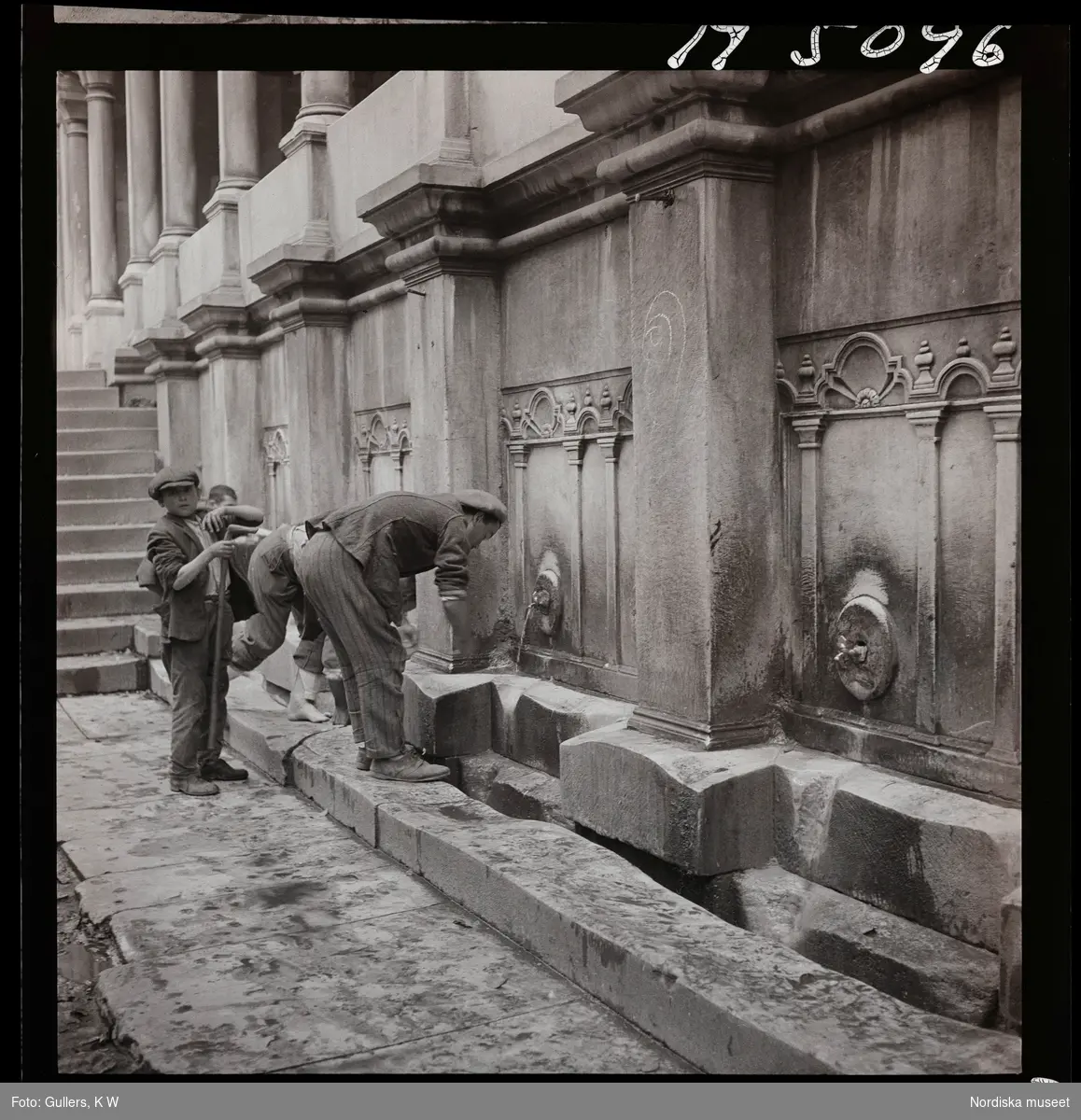 1717/L Istanbul allmänt. Män och pojke tvättar sig utanför moské.