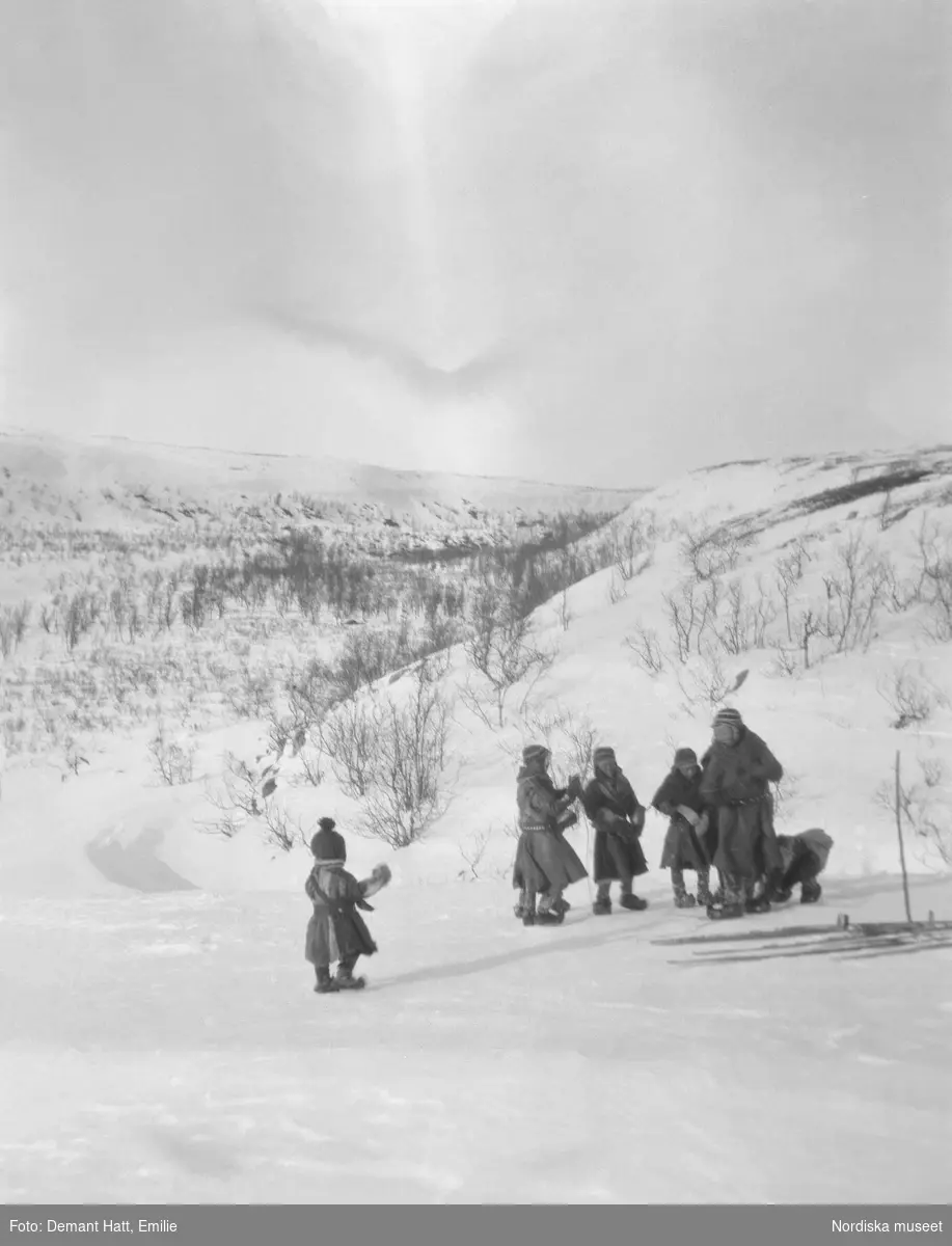 Barn leker i snön. Under vårflyttningen från Närvä. Bilden ingår i en serie fotografier tagna av Emilie Demant Hatt i Sapmi mellan åren 1907 och 1916.