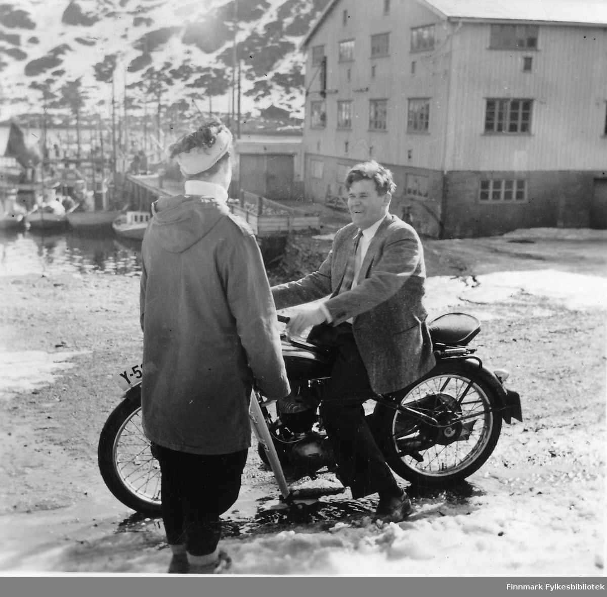 Havøysund 1957.  En dame prater med Trygve Olsen som sitter på motorsykkel.