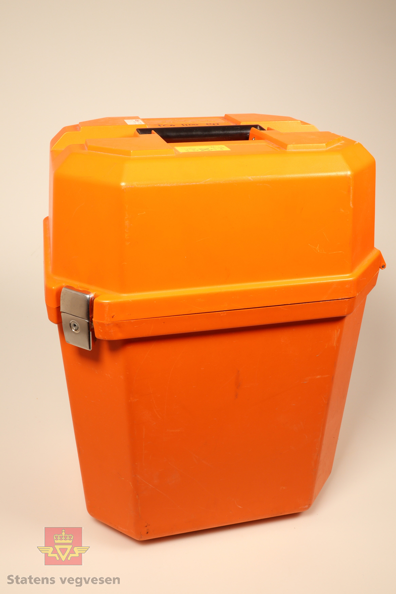 Grønn og svart totalstasjon med oransje koffert. I kofferten er det en totalstasjon oppå en GDF22 Fotplate, regntrekk, instruksjonsmanual, minnekort, mini prismestang med libelle og en LEMO ledning.