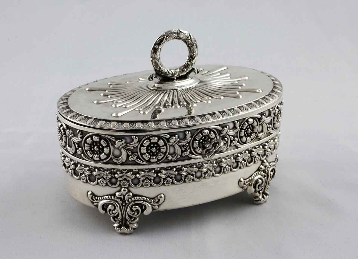 Ovalt sockerskrin av silver med lock samt lås och nyckel.