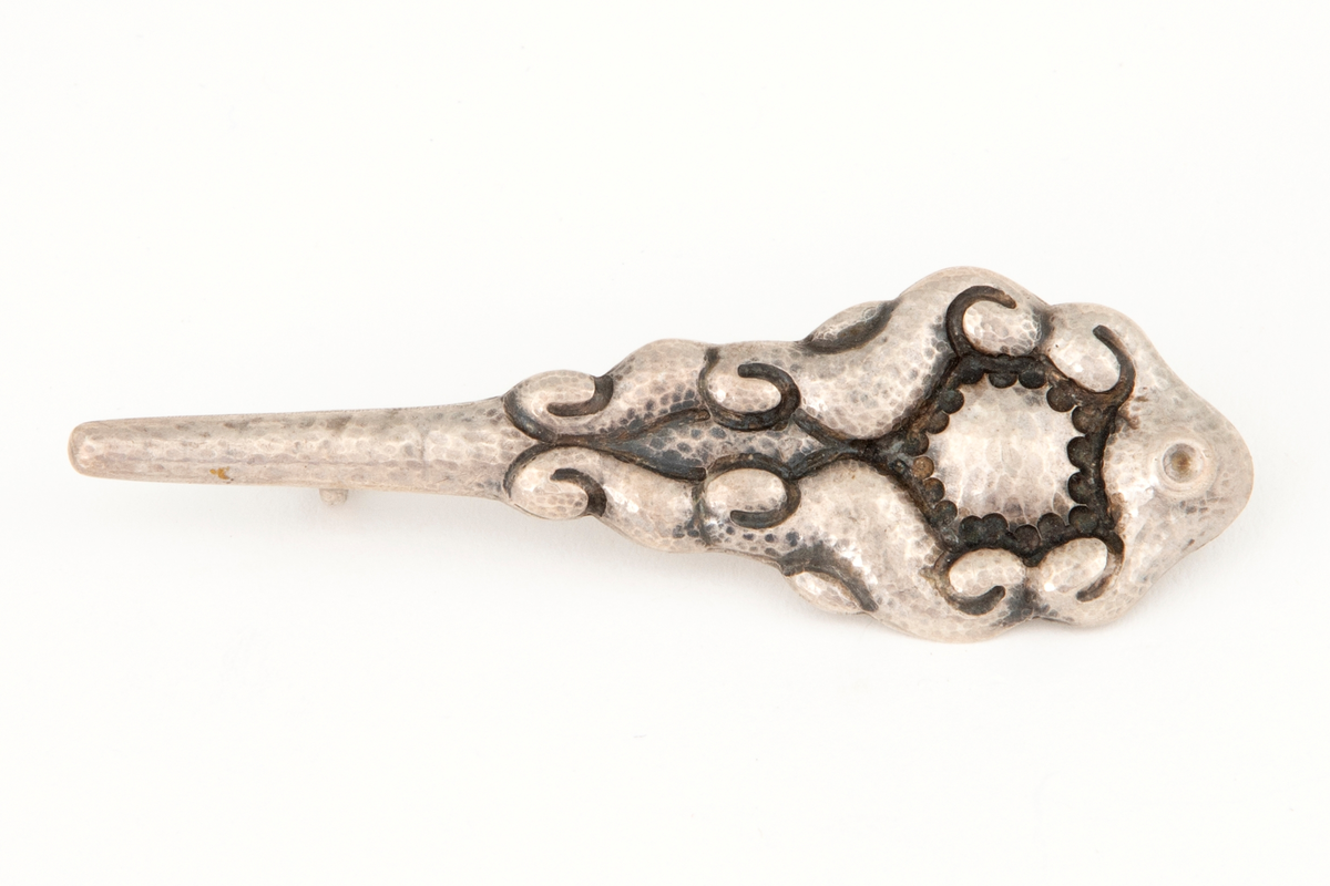 Brosje/ nål i sølv med blomsterlignende form og hamret overflate.