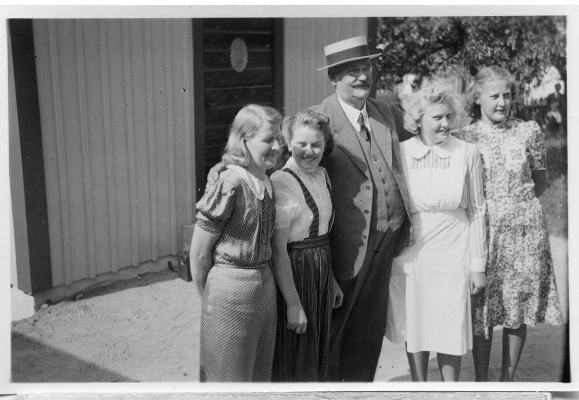 Fabrikör A E Bolling med stråhatt står omgiven av fyra unga kvinnor som arbetar på vandrarhemmet i Gränna.