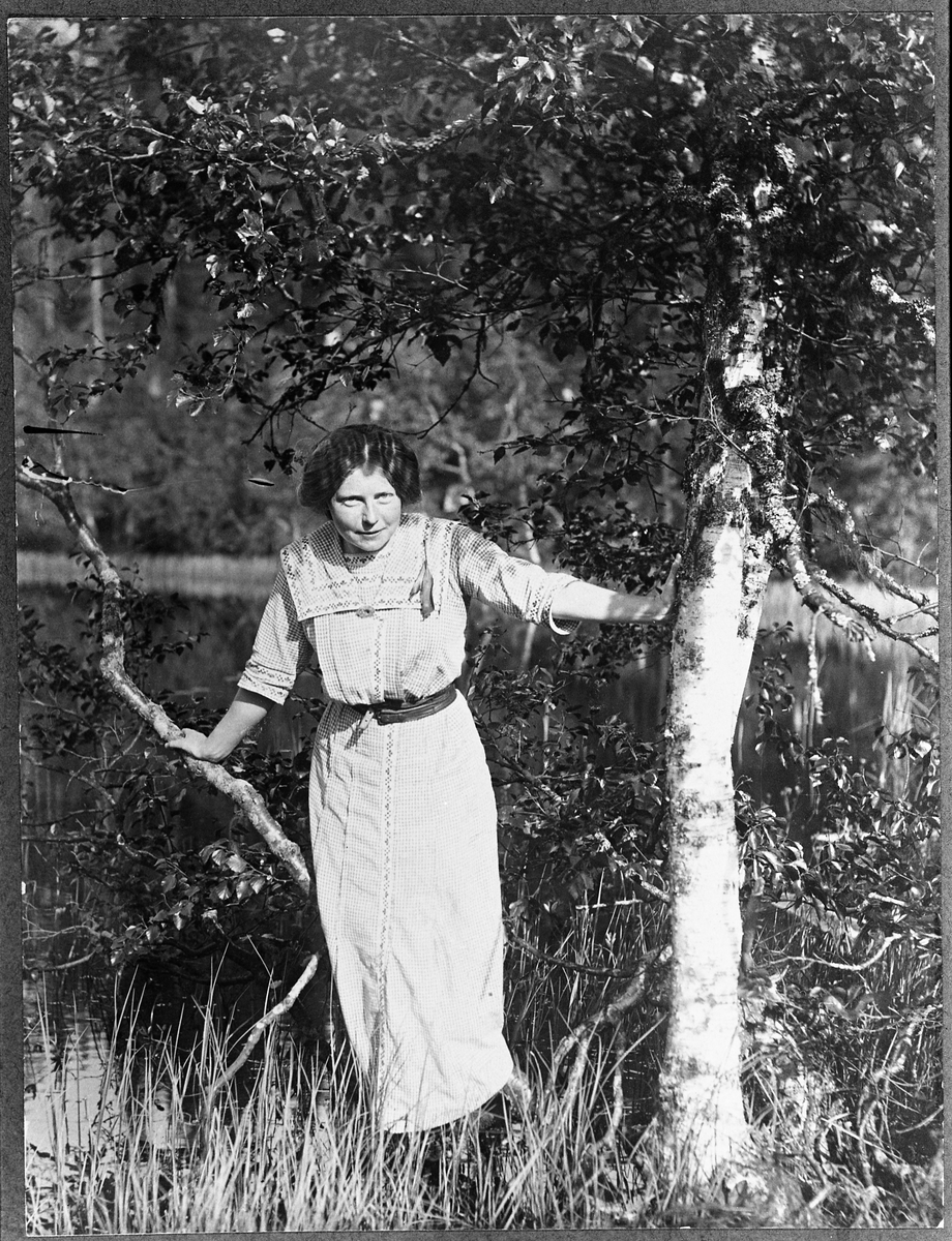 Helfigurs portrett av frøken Ramstad (fornavn ukjent). Bilde tatt ved et tjern i området Amundalen på Totenåsen året 1915.