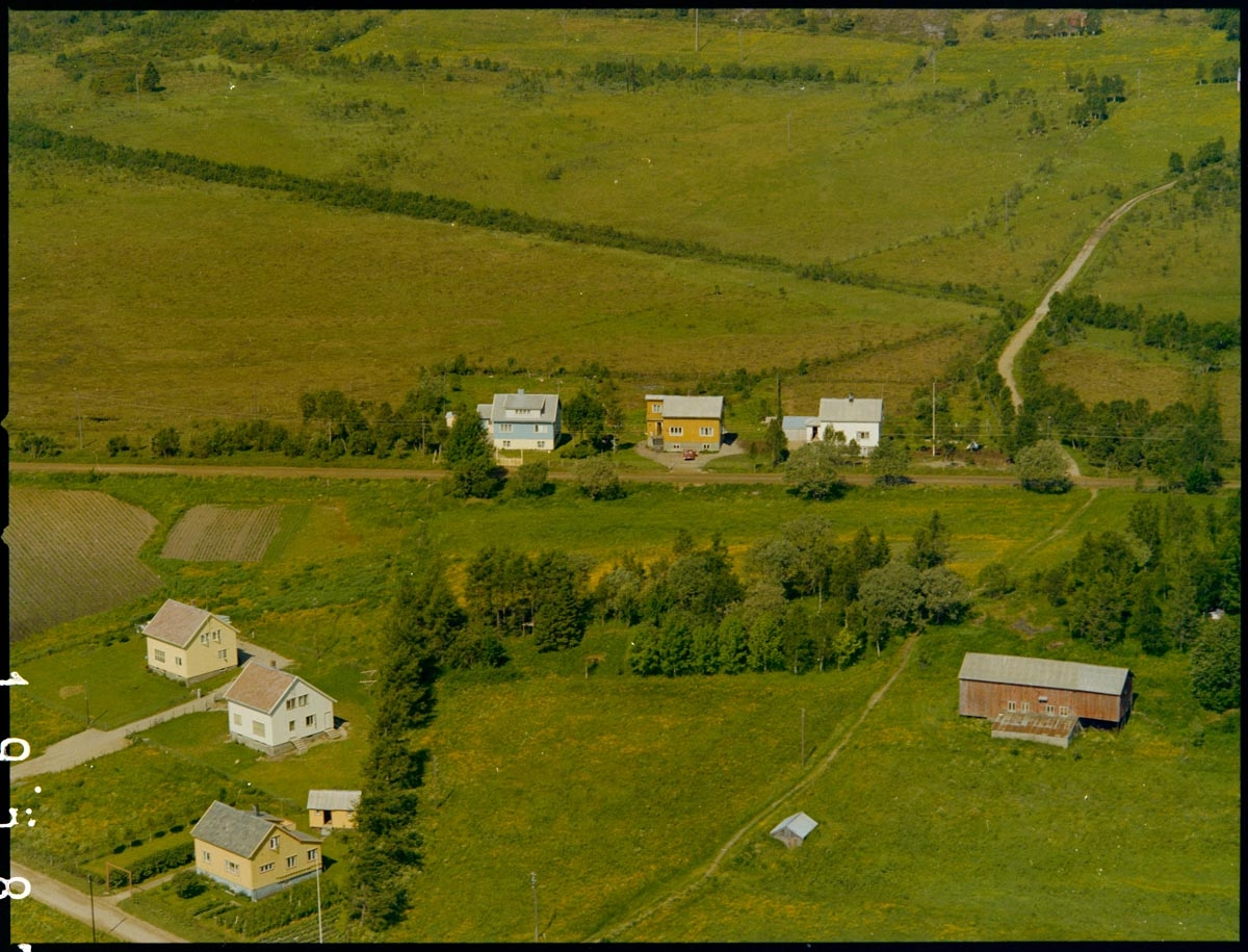 Leirfjord,Leland. Flyfoto. De tre husene til venstre i bildet var kommunale tjenesteboliger. De tre boligene midt i bildet ligger ved fylkesveien og Grubbveien ligger til høyre for disse. Peder Salomonsen bodde i en av disse tre husene.
