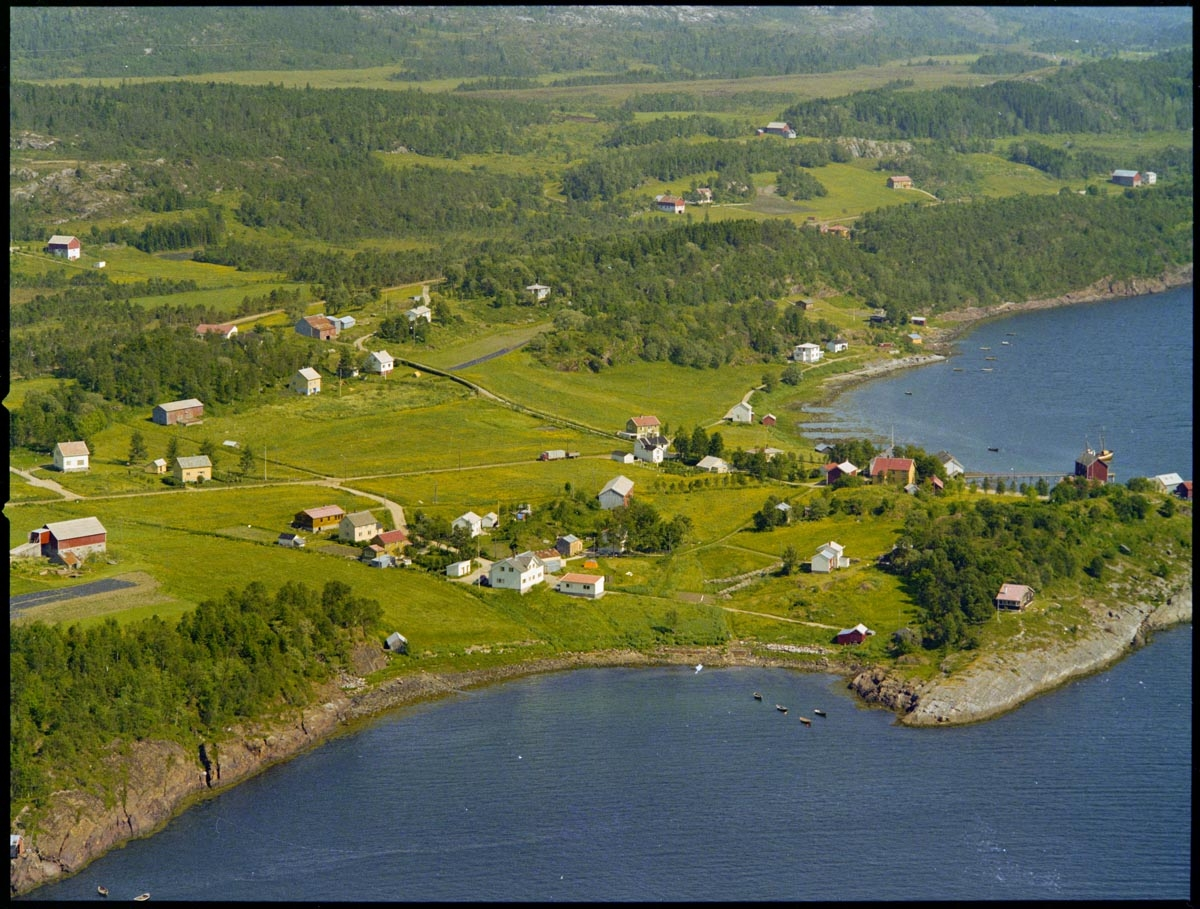 Leirfjord,Leland. Flyfoto fra område ved Breivika, Øverhåjen, Nerhåjen og jæra med jektestøer på Nedre-Leland ved siden av handelstedet og butikken til Bergh (nå museum).
