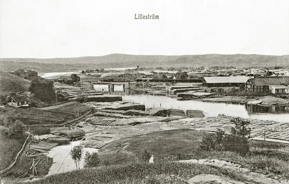 Utsikt fra Rudsberget mot Lillestrøm. Sagbruk og tømmeropplag i elva. Postkort. Foto: MiA-Museene i Akershus