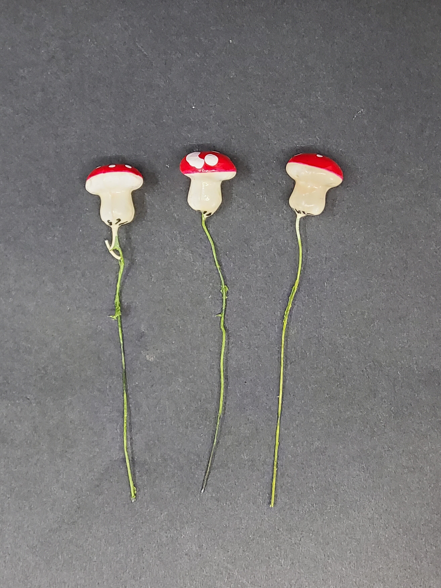 Tre flugsvampar i papier maché på ståltråd.