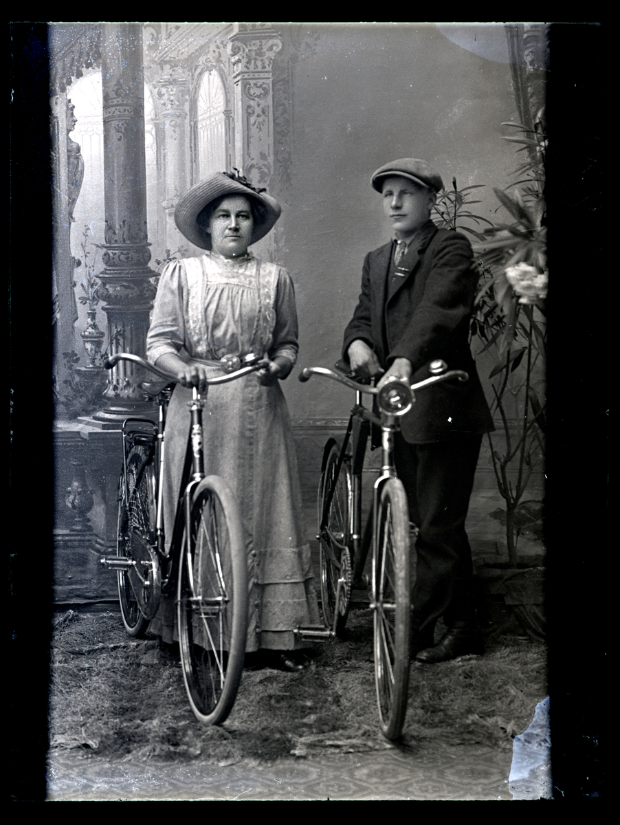 Atelierfoto. En kvinne og en ung mann med sykler.
Skrevet på negativet: Frk. Husa.