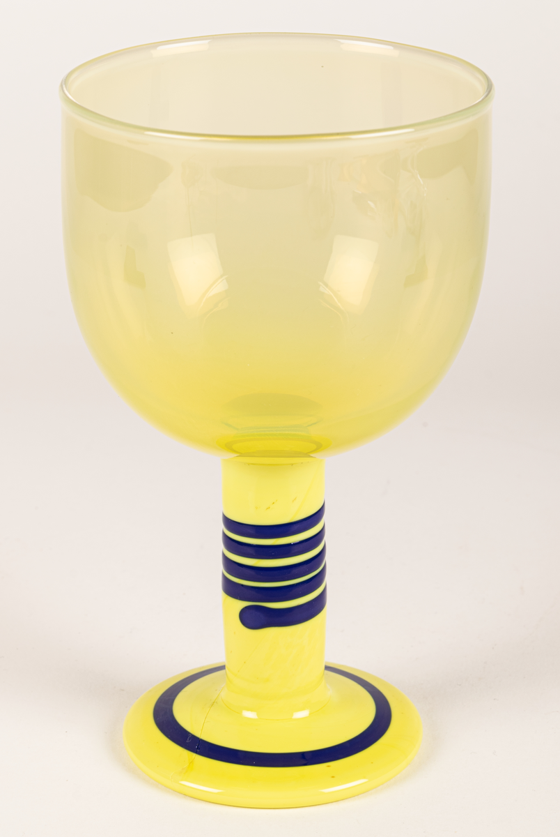 Popglas, gult med blåa ränder på foten.