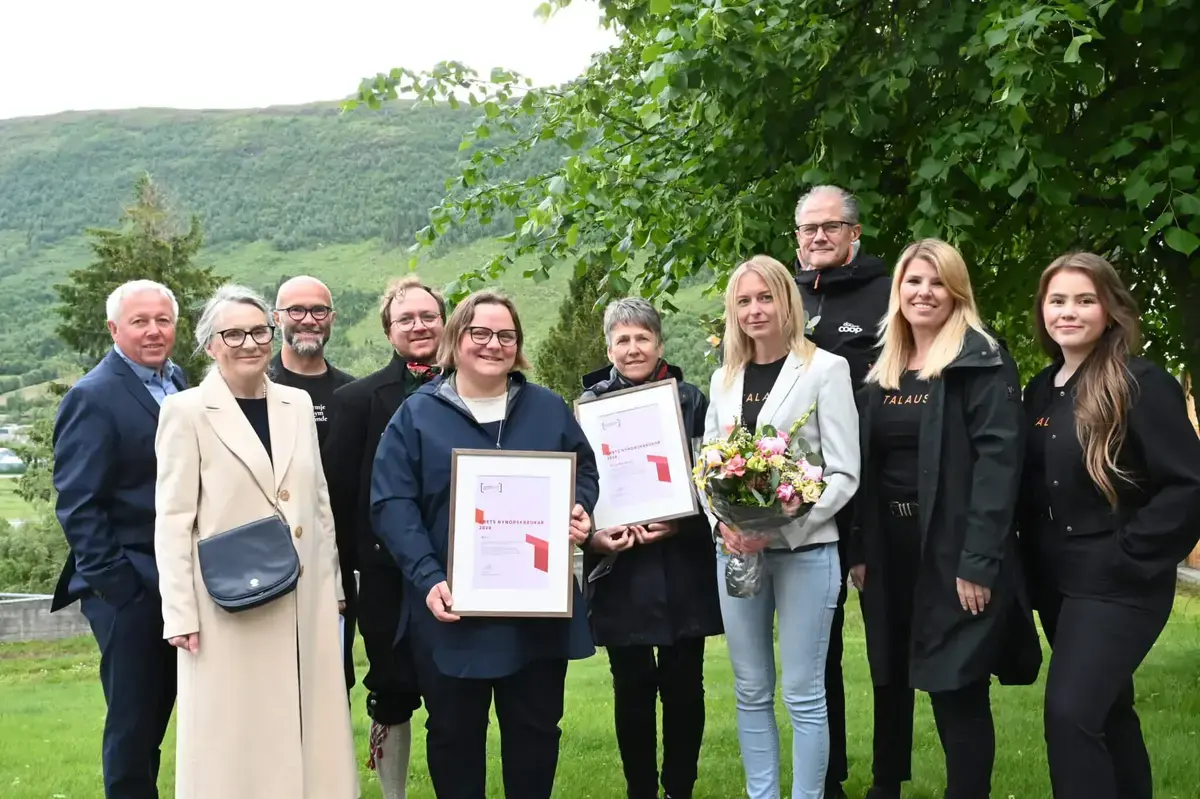 Gruppebilde med smilande personar med diplom og blomar