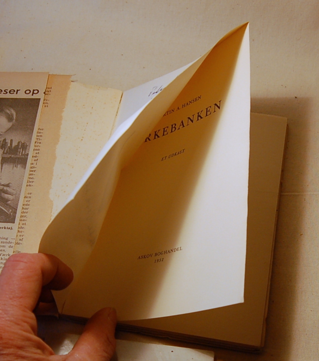På bokens forside et motiv med to figurer. Til venstre en menneskelignende figur som har noe i den ene hånden. Til høyre en figur muligvis med vinger som bærer et kors.