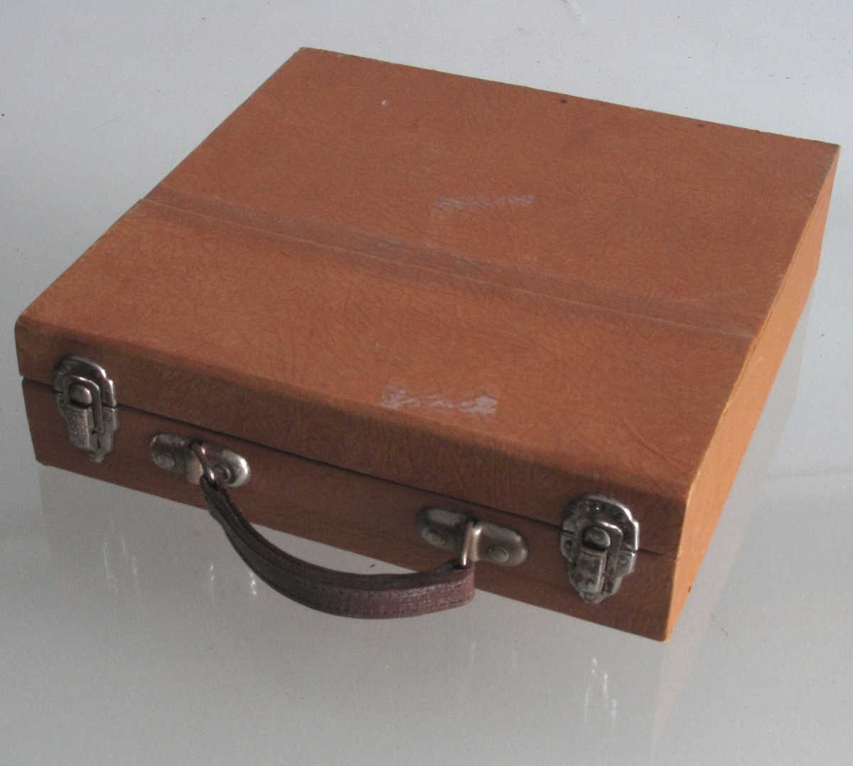 Liten koffert, inneholder 15 lydplater, tekstbok og hefte med ordliste + tekst til platene.