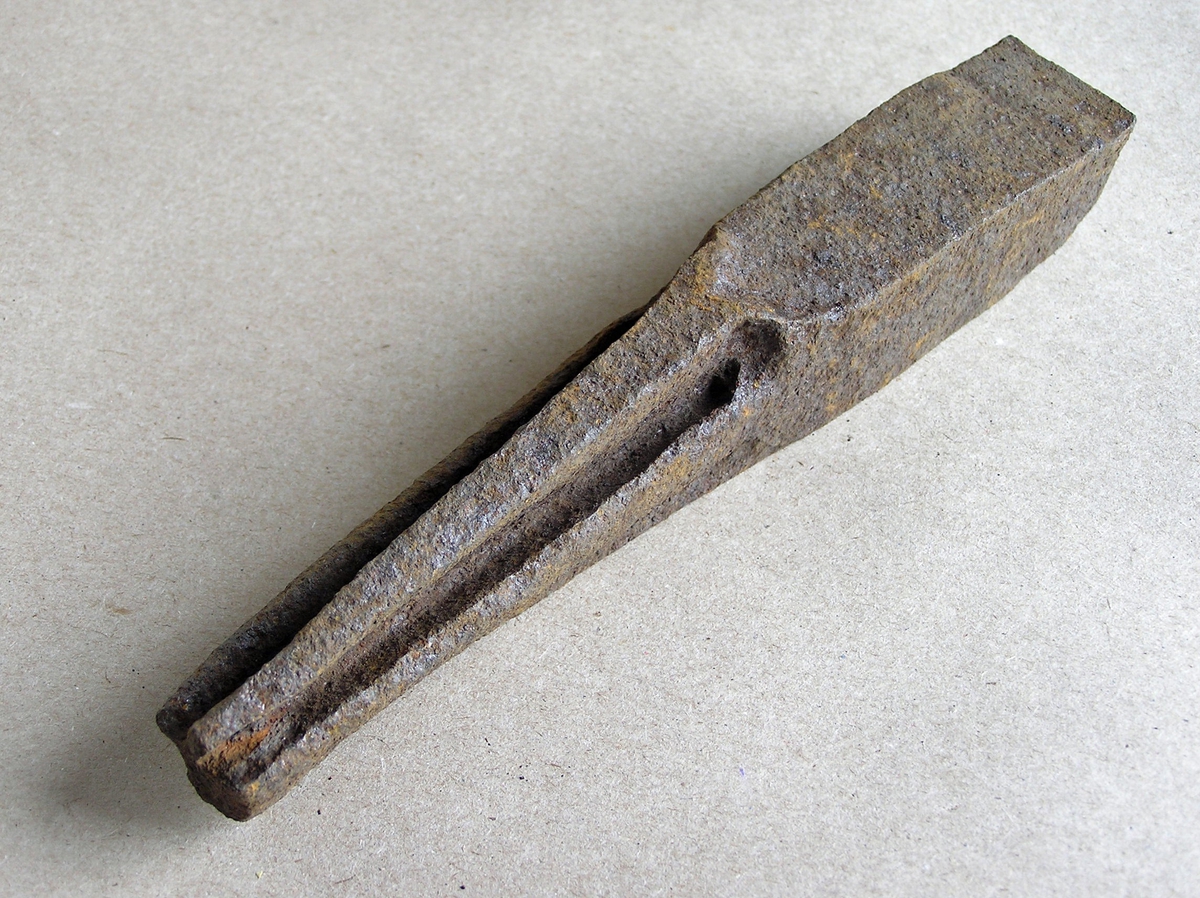 Smidd jernstykke til bruk ved smiing av merkeøks. Merket ble formet rundt stempelet. Stempeldel og håndtak i ett. Noe rust.