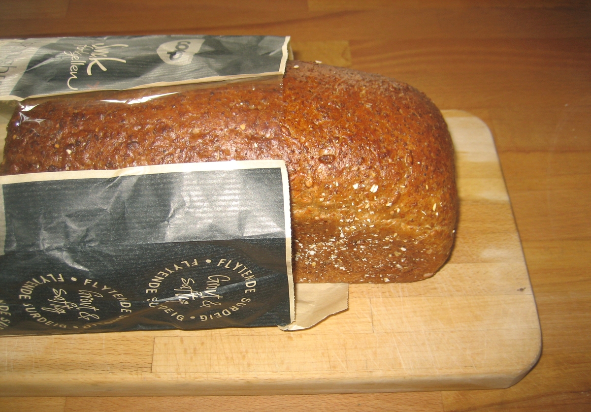 Motiv på posen er brød. Det ligger to skiver foran et oppskåret brød.  Ved siden av brødet er en bolle med smør, der det er plassert en kniv.