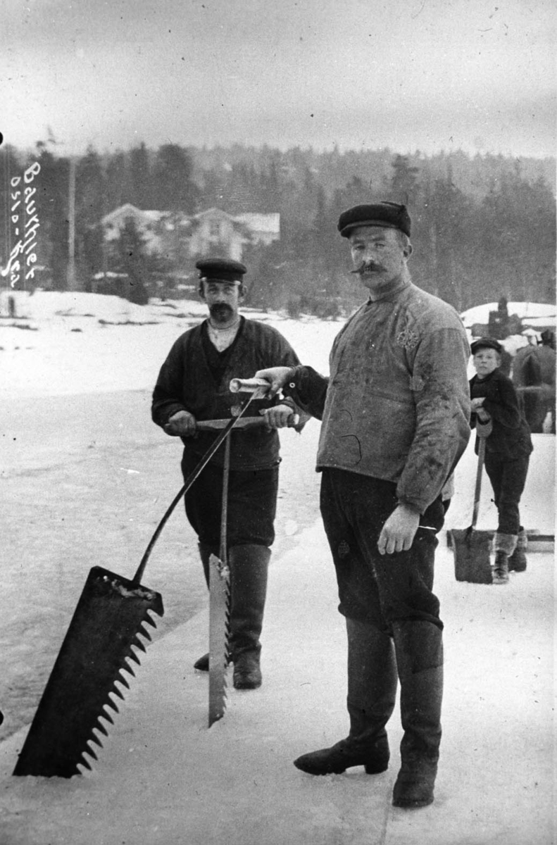 To menn som skjærer is. Mann med sneskuffe i bakgrunn