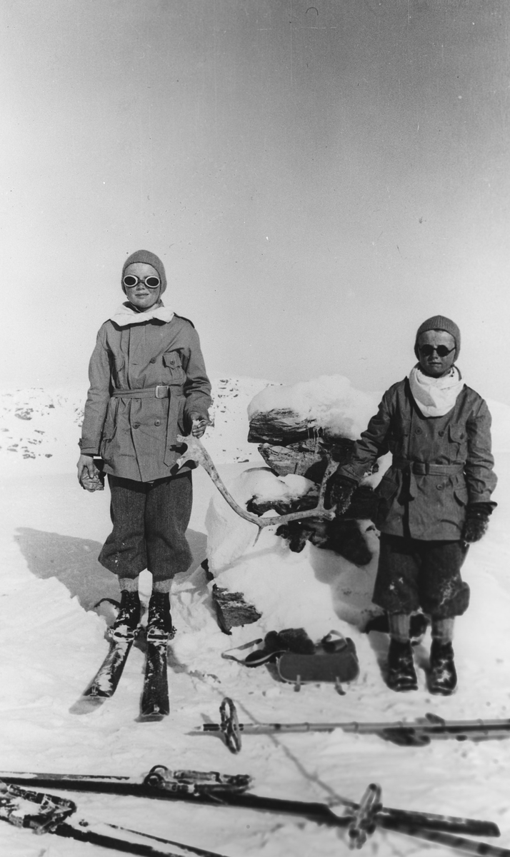 To barn på skitur, på toppen foran varden.