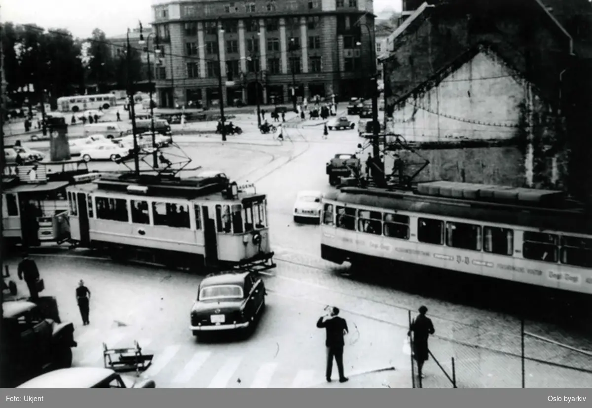 Oslo Sporveier. Trikker (bl.a. Sagenetrikken) passerer ved torget på spor 4 og 5. Trafikkmiljø. Jernbanetorget 2 (Den Norske Amerikalinjes hovedkontor) bakerst. Bildet fra 1960-tallet.