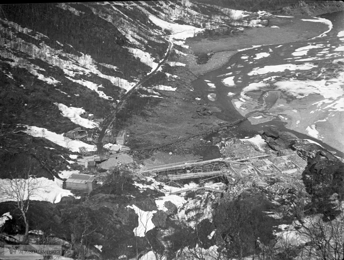 Frå bygginga av kraftstasjonen i Hallarvassfossen. .I bakgrunnen ser vi Nedre Sandvatnet med Arbeiderbrakkene i Sandvassøya lengst bak. Det var det tyske firmaet Nordag som kjøpte Aura-anlegget av Bergen Privatbank. De tyske planene ble skrinlagt i 1943.