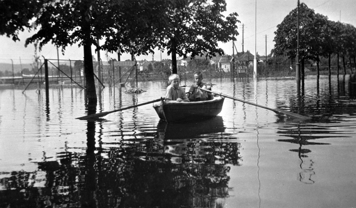 Hamar, Strandgata, Enggata, flom 1927, Mjøsflommen 1927, Christian W. Lindmann og Hans Theodor Landstad ror i en selvlagd seilduksbåt i Strandgata,