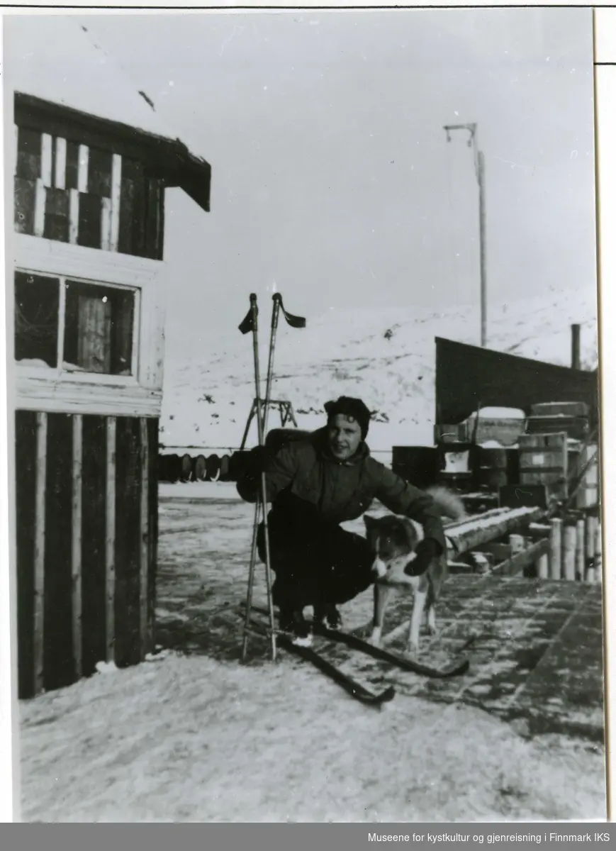 Handelsbetjent hos Schanche Håkon M. Hansen med hunden Kiso. Bjarne Schanches kai og trandamperiet til venstre. Pakkhuset til høyre. 1937.