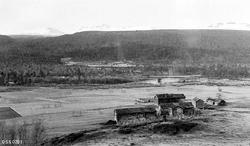 "Fra Hatfjelldal statsskoger. Gården Trallerud. I bakgrunnen