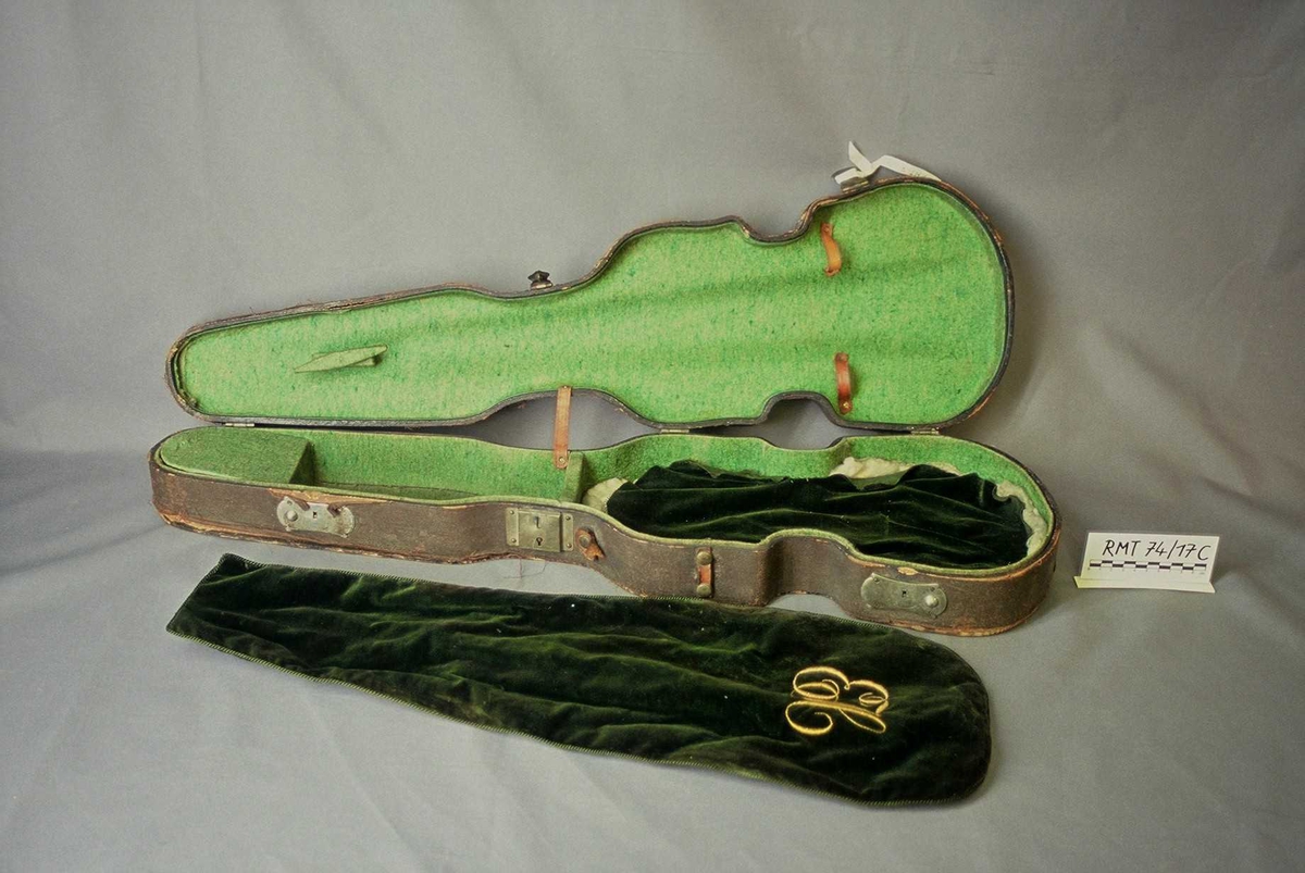 Papp-kasse trukket med svart lerret, foret med grønn filt, to buer, grønt fløyelsklede brodert i gult med initialene EH som var givers svigerfar.

