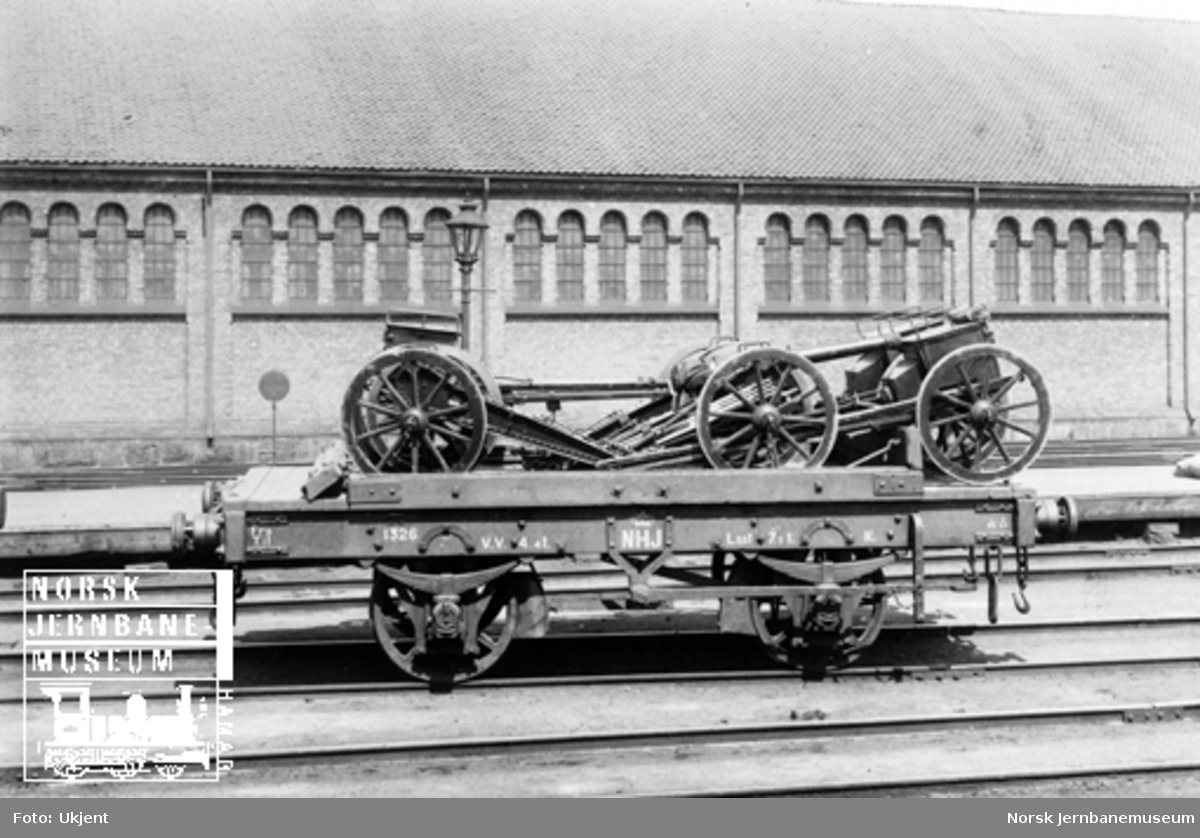 Hovedbanens vogn litra K nr. 1326 lastet med artillerimateriell; tre lavetter