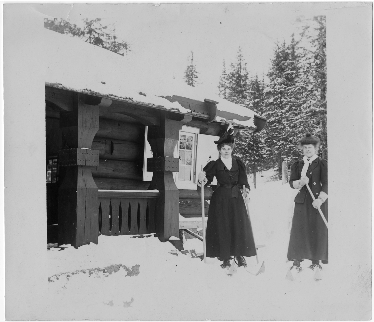 Kvinner på ski foran bygning, ukjent sted.
Serie tatt av Robert Collett (1842-1913), amatørfotograf og professor i zoologi. 