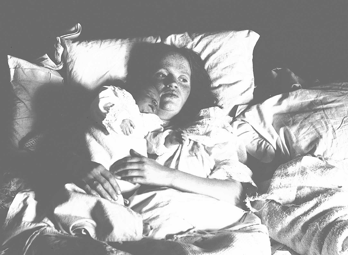 Kvinne i sengen med spedbarn. Mor Margrethe Q. Wiborg og lille Margrethe (?), Digerud, Frogn,  Akershus, 1907.
