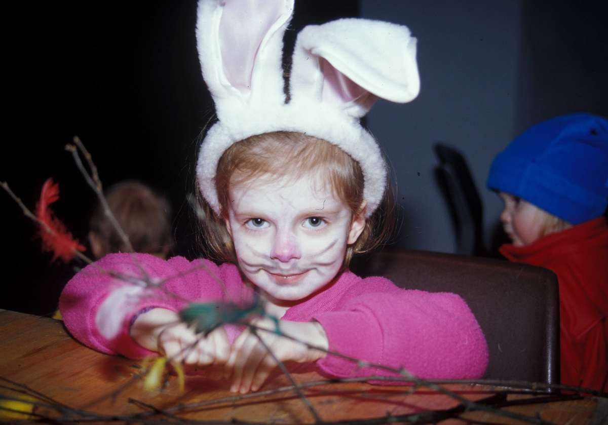 Feiring av fastelavn på Norsk Folkemuseum. Barna lager fastelavnsris i Hallen. Her en liten jente med store kaninører og ansiktsmaling.