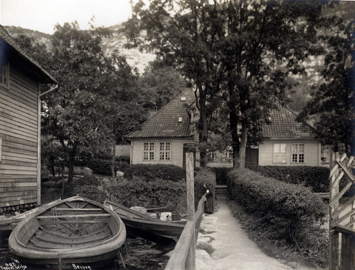 Trehus med robåter i forgrunnen, Sandviken, Bergen, Hordaland. Fotografert 1912.