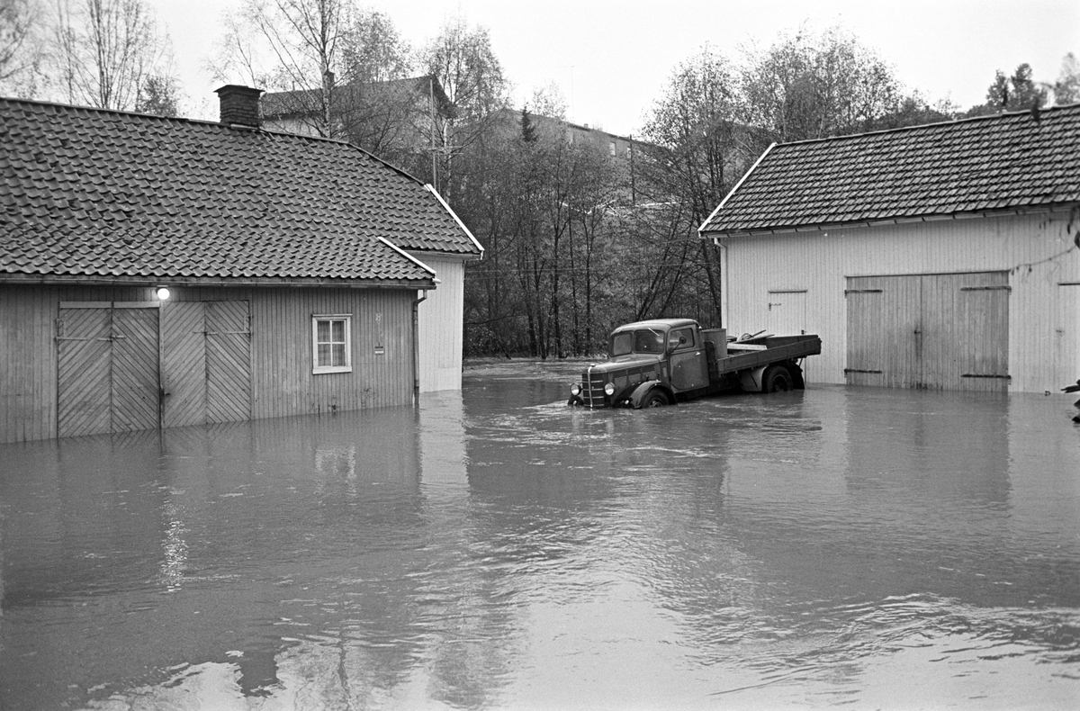Serie. Stor flom i et boligområde i Røyken. Flere boliger står med vann opp til vinduene. Fotografert oktober 1964.
