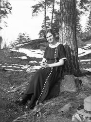 Dordi Arentz sitter lent mot et tre ved Nordre Skøyen. Fotog