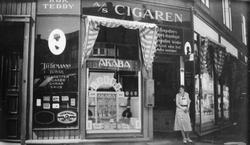 En kvinne står i inngangen til tobakksforretningen Cigaren A