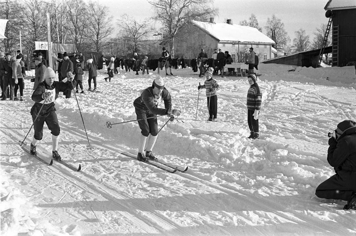 Skiløpere i målområdet under NM i langrenn for juniorer på Eidsvoll 1963. Publikum i bakgrunnen.