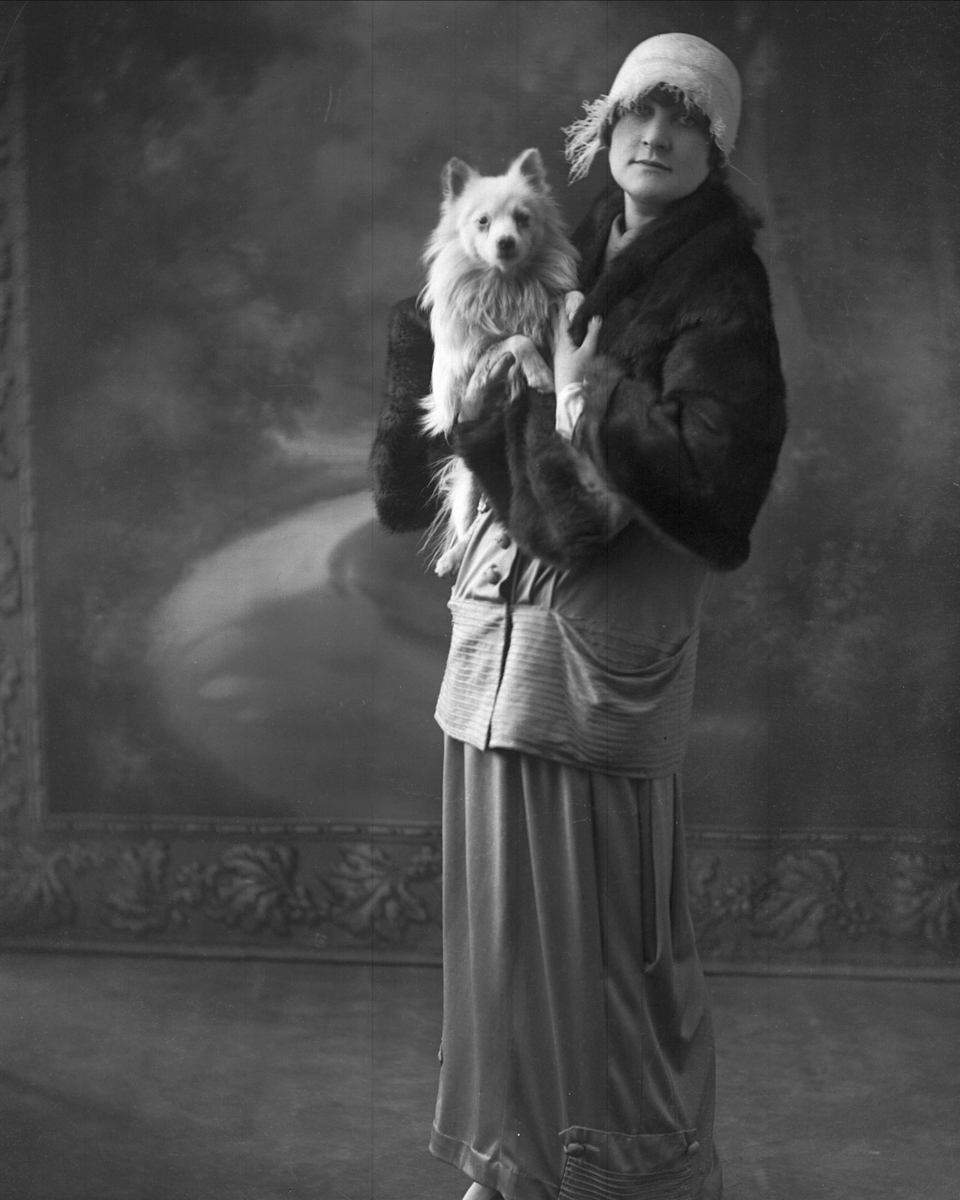 Portrett, kvinne med hund i fanget.